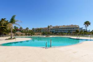ein großer Pool mit einem Gebäude im Hintergrund in der Unterkunft MalagaSuite Casa Oceano in Mijas Costa