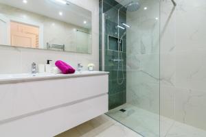ein Badezimmer mit Waschbecken und Glasdusche in der Unterkunft MalagaSuite Casa Oceano in Mijas Costa + 16 Fotos