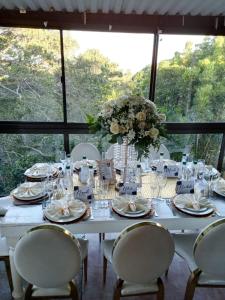 Stesh Margate Holiday House 12 Sleeper في مارغيت: طاولة بيضاء مع كراسي و إناء من الزهور