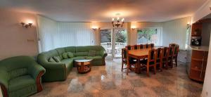 a living room with green couches and a table at Casa Jax in Rîmeţi