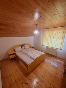 a bedroom with a bed and a wooden ceiling at Casa Jax in Rîmeţi