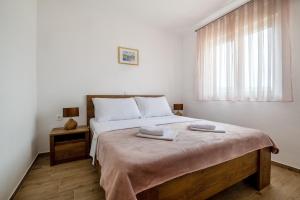 a bedroom with a large bed with two towels on it at Apartments Glorija in Neum