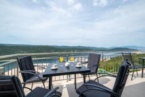 Una mesa y sillas en un balcón con vista al mar. en Apartments Glorija, en Neum