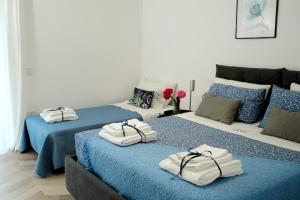 Dos camas con toallas en una habitación. en DANLÚ, en Salerno