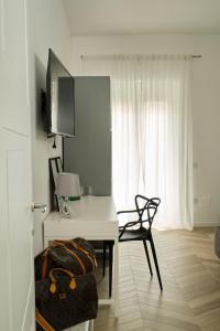 um quarto branco com uma secretária, uma cadeira e uma janela em DANLÚ em Salerno