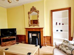 a living room with a fireplace and a mirror at Georgian 2 Bedroom Apartment in Edinburgh
