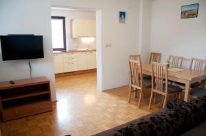 ein Wohnzimmer mit einem Tisch und einer Küche in der Unterkunft Apartments Lipa in Železniki