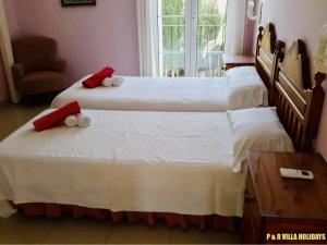 two twin beds in a room with a window at Villa Can Pere Cala Galdana Menorca in Cala Galdana