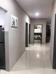a room with a hallway with white tile floors and paintings at Ipoh Manhattan TSL Pool View Water Park Homestay! in Kampong Pinji