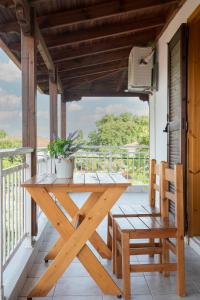 een houten tafel en stoelen op een veranda met uitzicht bij Gravanis Studios in Platamonas