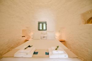 una camera con un letto con asciugamani e una finestra di Trullo Cimì with Private Pool a Francavilla Fontana