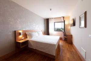 a hotel room with a bed and a window at Torre Antica Venice Airport Hotel in Tessera