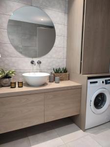 a bathroom with a sink and a washing machine at VagiaNa apartment Διαμέρισμα κοντά στο αεροδρόμιο in Antimácheia