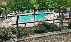 une clôture autour d'une piscine avec des tables et des chaises dans l'établissement Golfside Vacation Home 4, à Bella Vista