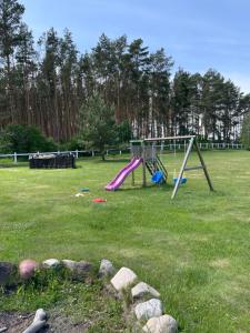 ein Spielplatz mit Rutsche in einem Park in der Unterkunft Lansada in Zabór