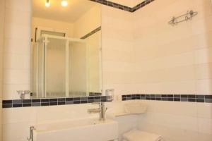 Un baño con lavabo, inodoro y espejo. en Donnafugata Relais, en Marina di Ragusa 37 fotos más