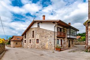 an old stone house on the side of a road at La casita de susa en mazcuerras in Villanueva de la Peña
