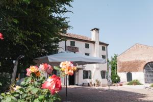 a building with an umbrella and flowers in front of it at Cá Scirocco in Ca Grignella