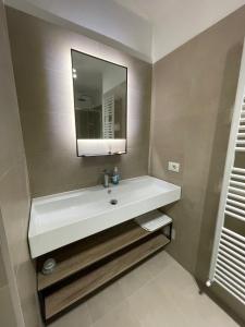 y baño con lavabo blanco y espejo. en Sisila Locazione, en Vittorio Veneto