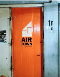 eine orangefarbene Tür mit einem Luftstadtbild drauf in der Unterkunft Airtown Guest House in Jetis