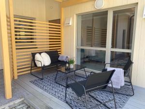 eine Terrasse mit 2 Stühlen und einem Tisch auf der Veranda in der Unterkunft Vanalinna apartment in Haapsalu
