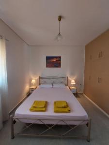a bedroom with a bed with two yellow towels on it at Saint George family house in Palaiá Fókaia