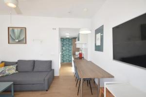 a living room with a couch and a table at Apartamentos ALAZUL JRJ in Conil de la Frontera