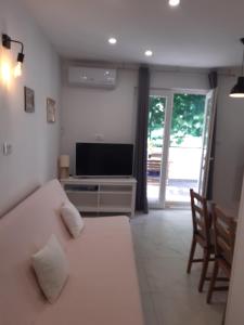 a living room with a couch and a television at Apartment Vanja konoba in Komiža