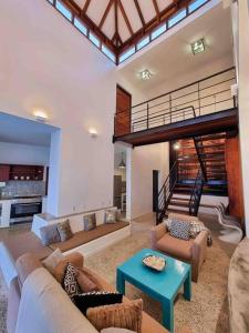 una gran sala de estar con sofás y una escalera. en Yemaya Villa Curaçao Unique-Oceanfront-Private stairway to sea!, en Willemstad