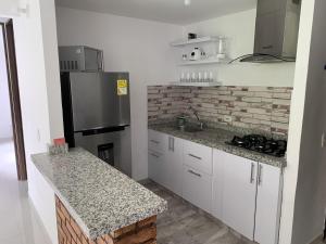 a kitchen with white cabinets and a black refrigerator at Mango Home in Ricaurte