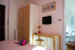 1 dormitorio con 1 cama y escritorio con TV en Hotel Giongo, en Spotorno