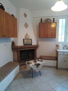 a living room with a fireplace and a table at Eleni's house II in Kóronos