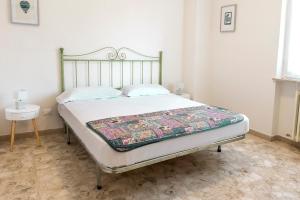 ein Bett mit einer Decke in einem Schlafzimmer in der Unterkunft N235 - Numana, ampio appartamento con terrazzo vista mare in Numana