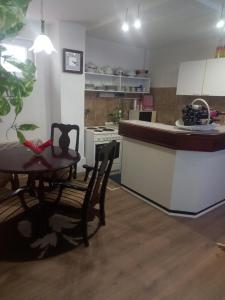 eine Küche mit einem Tisch, Stühlen und einer Theke in der Unterkunft Apartment Reni in Sarajevo