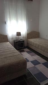una camera con due letti e un tavolo e una finestra di Lemon Tree a Ulcinj