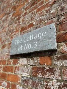 a sign on the side of a brick building at The Cottage at No. 3 in West Lavington