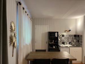 cocina con mesa de madera y cocina con nevera en Studio d’étape, robinson Plaintel, en Plaintel