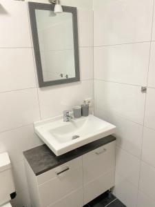 a bathroom with a white sink and a mirror at Geräumiges Maisonette Apartment in Todtmoos