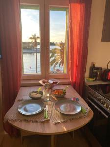 einen Tisch mit zwei Teller Essen drauf mit einem Fenster in der Unterkunft Studio Apartment Klokke in Supetar