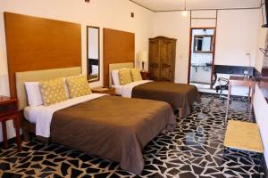 喬盧拉的住宿－Hotel Vitorina Cholula，一间酒店客房,房间内设有两张床