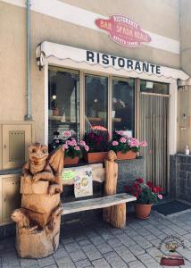 ein Restaurant mit einer Holzbank vor einem Geschäft in der Unterkunft Spada Reale in Valdieri