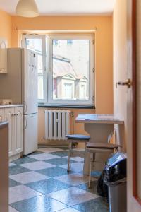 a kitchen with a refrigerator and a table and a window at roomspoznan pl - Rybaki 15 - 24h self check-in in Poznań