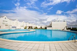 a large swimming pool next to some white buildings at Lighthouse North Villa - Praia da Barra in Praia da Barra