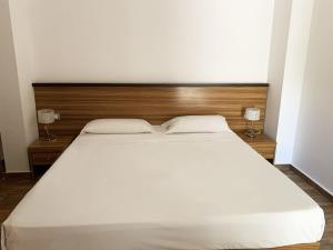 - un grand lit blanc dans une chambre avec deux lampes dans l'établissement Nuraghe Apartments, à Teulada