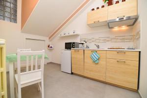 a kitchen with wooden cabinets and a white refrigerator at Artemide B&B in Pianillo