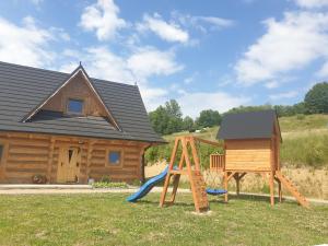 a log cabin with a slide and a playground at Górska Kryjówka in Poronin