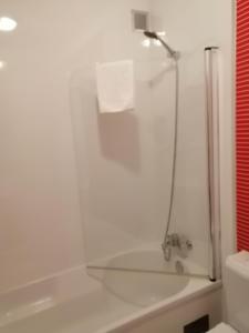 a bathroom with a bath tub with a shower at Hotel Classis in Bragança
