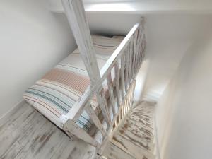 a wooden staircase in a room with a bed at Maison de la plage in Pirou