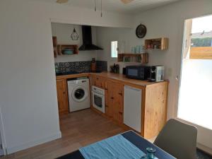 a kitchen with a washing machine and a washer and dryer at Maison de la plage in Pirou