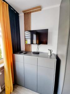 a room with a tv on top of a dresser at Apartament Luxusowe Karkonosze in Jelenia Góra